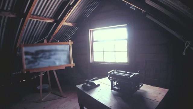 Wooden office in an attic of a writer, writer inspiration wooden cabin typewriter on a old desk. 4k