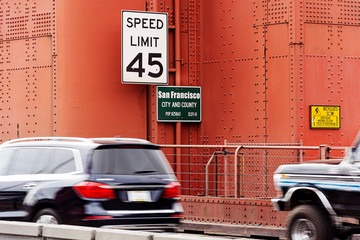 Traffic signs about speed limits and information panels on a tower of the Golden Gate Bridge in San Francisco