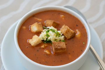 Tomato soup with croutons, cheese and fresh parsley, closeup