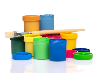 Set of Colorful Gouache jars and artist brushes isolated on white background with copy space. Cans of different colors gouache paints.