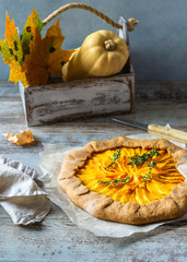 Autumn pie - pumpkin galette on grey wooden rustic table. Thanksgiving day food.