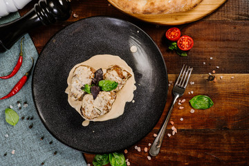 Grilled meat medalions with sauce on the wooden background