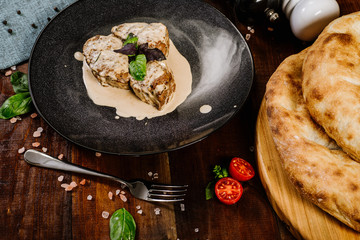 Grilled meat medalions with sauce on the wooden background