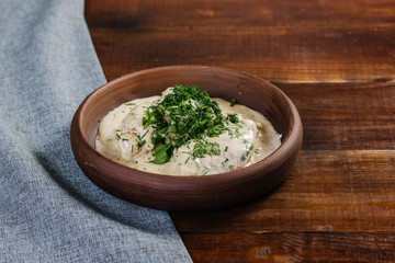Dish with chopped meat with sauce and herbs on the wooden background