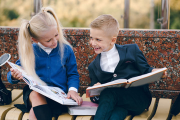Little students go to school. Schoolchildren on background of flags of foreign countries.