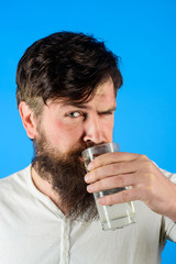 Healthy nutrition. Young man drinking fresh glass of water. Drinking water. Handsome bearded man holds glass of fresh water. Man drinking water in morning. Hydration, health care and drink concept.