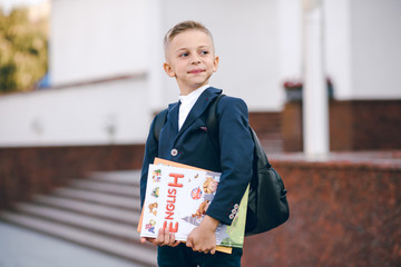 Little schoolboy with books in her hand. Back to school.