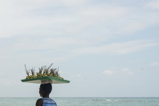 Young girl carrying quenepas on her head, Haiti 