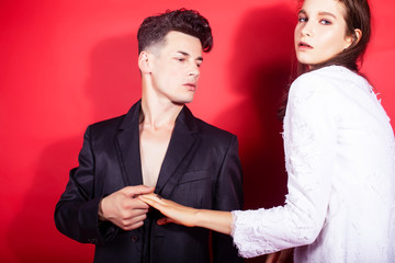 young fashion style couple man and woman on red background, luxury stuff, lifestyle modern people sale concept