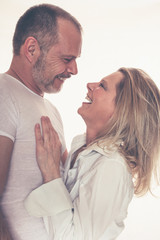 Portrait fröhlich lachendes älteres Paar schauen sich in die Augen Umarmung weißer Hintergrund
