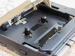 Portable personal audio cassette player. Close up showing dusty interior where cassette tape would be placed. Genuine retro personal music system from the 1980s.