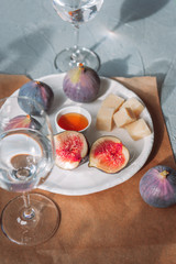 Figs, cheese and honey on a white plate