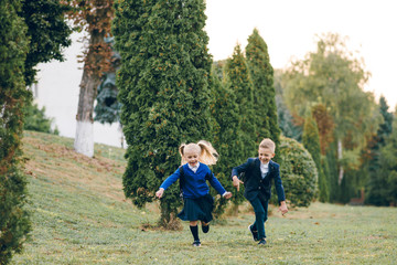 Cute kids with backpacks on their back running to school having fun. Back to school.