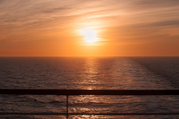 Awesome sunset and wake left on the sea by a cruise ship