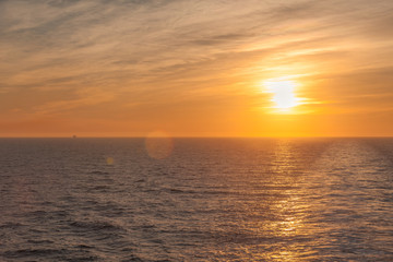 Beautiful sunset on the sea where you can see the wake left by a cruise ship
