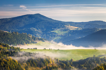 Fog in the valleys of the mountain landscape in autumn morning. The Orava region near the village of Zazriva in Slovakia, Europe.