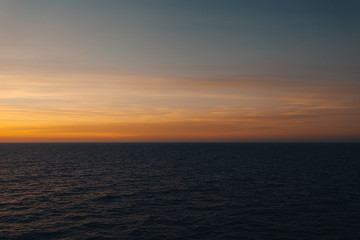 Horizon of the sea and awesome orange-colored clouds after sunset