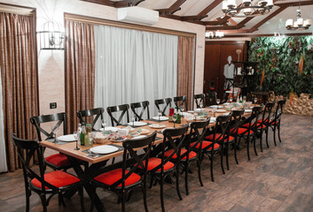 18 person table for dinner with black wooden chairs with red seats