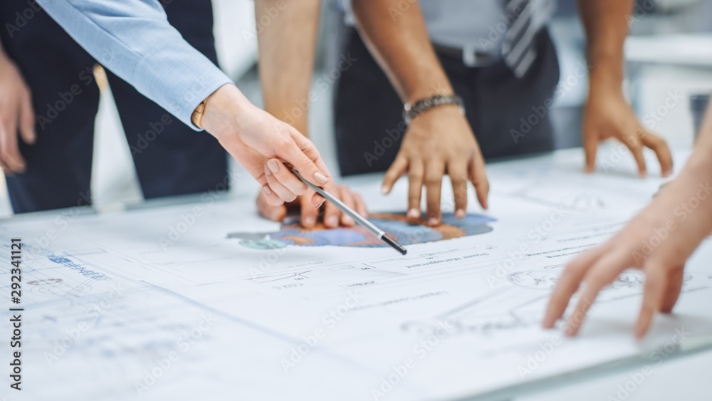 Poster Industrial Engineering Facility: Close-up on Hands of Group of Engineers, Technicians and Specialists on a Meeting, Tracing Lines and Analysing Engine Design Technical Drafts Laying on the Table