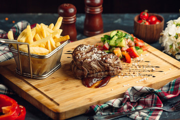 Beef steak with pomegranate sauce, french fries and fresh salad
