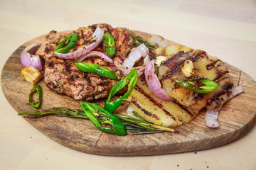 Grilled pork with pineapple, red onion and hot green pepper. Serve on a wooden board.
