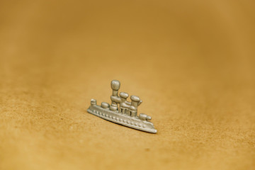 small miniature ship gray on a brown background