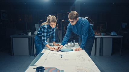 In the Dark Industrial Design Engineering Facility Male and Female Engineers Talk and Work on a...