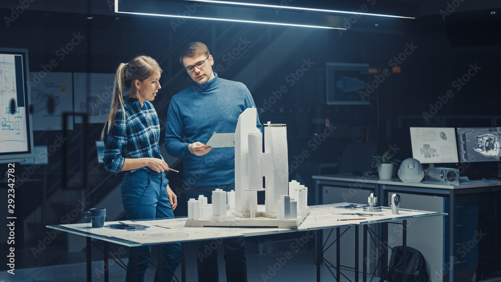 Fototapete in the creative architectural bureau two professional engineers work on a model of a city district. 