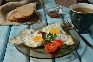 Fried eggs with tomatoes parsley bread tomato sauce and tea.