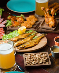 Dried smoked fish as beer snack with nuggets, beer, pistachio