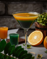 Exotic cocktail in cocktail glass with orange and green juice