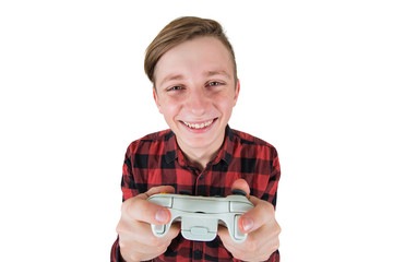 Joyful teen boy playing video games isolated over white background. Excited adolescent stand all ears holding a joystick console looking attentive try to win, having fun in the virtual world. © 1STunningART
