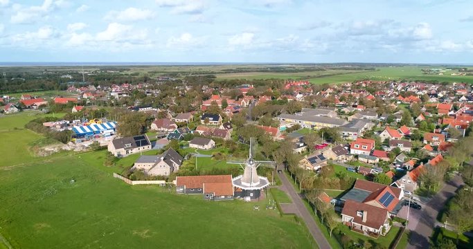 A Traditional Windmill “De Verwachting” in Hollum, the Dutch Island Ameland, The Netherlands. Flying Backwards. 4K Drone Footage.