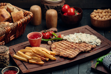 Grilled chicken fillet with creamy mushroom sauce, fries and ketchup