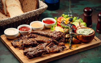 Grilled steaks with vegetable salad, mushroom, four sauces, yoghurt with fresh herbs
