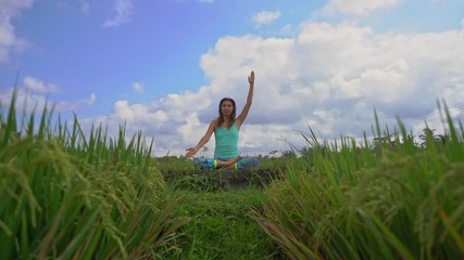 Slowmotion steadicam shot of a young woman doing meditation for Muladhara chakra in a Balinese way