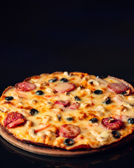 Pepperoni pizza with pepperoni, olive cheese in black background
