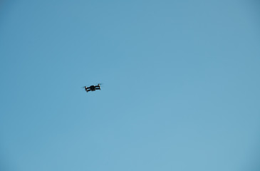 Black drone in the blue sky. Freedom concept