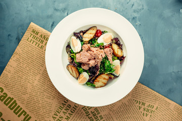 Tuna salad with lettuce, frilled potato halves, hard boild eggs, sesame sprinkles