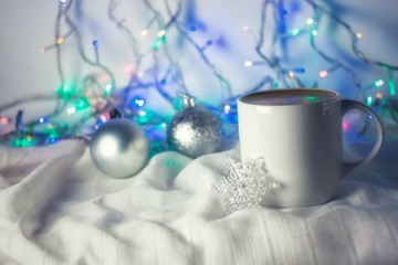 Fototapeta na wymiar Christmas coffee cup with new year decorations on background. Winter holidays card, cozy home concept, festive wallpaper. White mug with hot drink. Copy space with bokeh lights