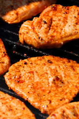 beautiful grilled roasted meat steaks grilled on the street on a black metal grill on burning coals, picnic concept, close-up