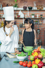 Cute little asia girl and beautyful woman chef