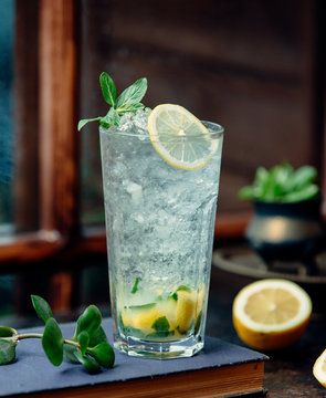 A close up of mojito glass with lemon and ice shaving