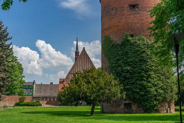 A tower in a park with a church in the background - 292349159