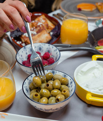 Bowls of olive and raspberry orabge juice and wrapped pancakes