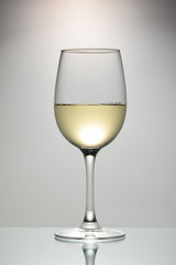Glass goblet with white wine and a bright background with a vignette.