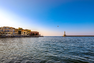 Obraz premium Interesting photo of Chania harbor with bird between old town and lighthouse.