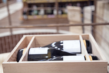 three bottles of wine in a box on the background of store shelves