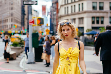 Woman in yellow dress walking on a busy New York street