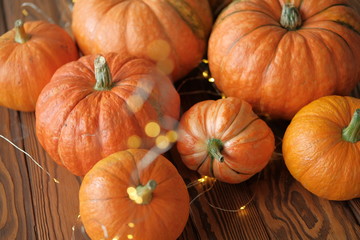 pumpkins with a shining garland on a wooden table